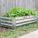 Rectangle, silver raised garden bed outside with plants growing inside