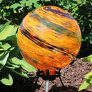 Sunset sky gazing ball globe displayed in the garden.
