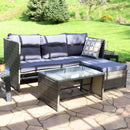 Purple, resin wicker patio sectional with gray cushions and resin wicker coffee table with glass top sitting in front.