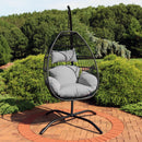 hanging egg chair with gray cushions and black metal stand