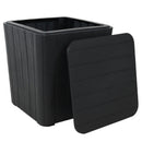 Black, faux woodgrain side table with storage with lid off, resting on the side of the box.